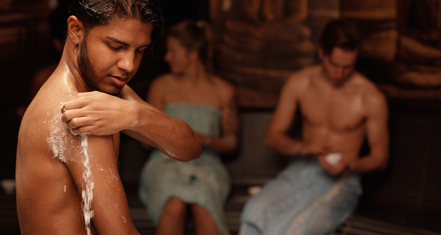 Jonge man scrubt schouder tijdens Ceylon wellnessritueel